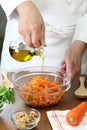 Making grated carrot salad, pouring olive oil