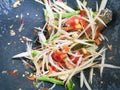 Making of green papaya salad with ingredients crab dried shrimp are mixing and pounding in a mortar. we call ` Som tum ` in Thai