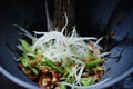 Making of green papaya salad with ingredients crab dried shrimp are mixing and pounding in a mortar. we call ` Som tum ` in Thai