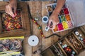 Making of handmade jewellery. Box with beads on old wooden table. Top view with woman hands - tutorial to learn how to make Royalty Free Stock Photo