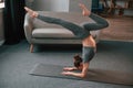Making handstand. Young woman in yoga clothes doing fitness indoors Royalty Free Stock Photo
