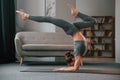 Making handstand. Young woman in yoga clothes doing fitness indoors Royalty Free Stock Photo