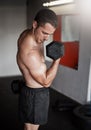 Making his bicep bulge. a handsome and muscular young man working out with a dumbbell in the gym. Royalty Free Stock Photo