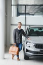 Making his choice. Horizontal portrait of a young man in a suit looking at the car and thinking if he should buy it Royalty Free Stock Photo