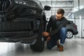 Making his choice. Horizontal portrait of a young man in a suit looking at the car and thinking if he should buy it Royalty Free Stock Photo