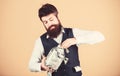 Making his savings in dollar. Businessman taking dollar cash out of glass jar. Bearded man hiding american dollar Royalty Free Stock Photo