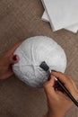 Making homemade crafts - pumpkin for Halloween from papier-mache, stick pieces of napkins with a brush, DIY