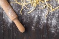 Making homemade pasta linguine on rustic kitchen table with flour, vintage sieve and cutting board