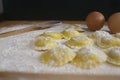 Making homemade Ravioli / Tortellini /dumpling with eggs on floured wood