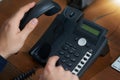 Making that important call. an unrecognizable man dialling a number on a telephone.