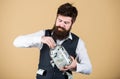Making an investment. Businessman taking cash money out of glass jar for investing activities. Bearded man investing Royalty Free Stock Photo