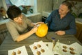 Making Jack O`Lantern at home. The process of creating a Jack O`Lantern theme template. A man and a woman are preparing a pumpki