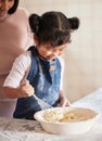 The making is just as fun as the eating. an adorable little girl baking with her mother at home. Royalty Free Stock Photo