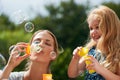 Making lifelong memories together. Shot of a young mother blowing bubbles with her daughter. Royalty Free Stock Photo