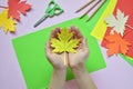 Making maple leaf from colored paper with your own hands for decoration of greeting card. Handmade crafts. Hello Autumn concept. C