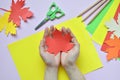 Making maple leaf from colored paper with your own hands for decoration of greeting card. Handmade crafts. Hello Autumn concept. C