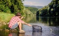 Making me happy. mature bearded man with fish on rod. successful fisherman in lake water. hipster fishing with spoon Royalty Free Stock Photo