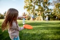 Making memories, breaking the distance. Little girl playing frisbee with her family in the park on a sunny day Royalty Free Stock Photo