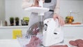 Making minced meat in electric meat grinder from fresh beef at home. Electric mincer machine with fresh chopped meat Royalty Free Stock Photo