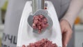 Making minced meat in an electric meat grinder from fresh beef at home. Pile of chopped meat. Electric mincer machine