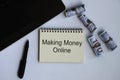 Making money online text on notepad with money and laptop background. Royalty Free Stock Photo