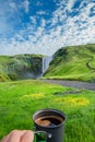 Making morning coffee in front of famous Skogarfoss waterfall, while hiking in Iceland, summer, scenic view Royalty Free Stock Photo