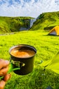 Making morning coffee in front of Skogarfoss waterfall, while hi Royalty Free Stock Photo