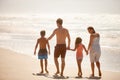 Making the most of a beautiful day. Rearview shot of a family enjoying a walk along the beach. Royalty Free Stock Photo