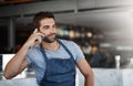 Making moves to grow his bar. a young man using a mobile phone while working at a coffee shop. Royalty Free Stock Photo