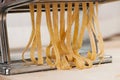 Making noodles with pasta machine from homemade spelt dough. Royalty Free Stock Photo