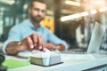 Making notes. Blurred photo of young bearded businessman taking white note paper to write something while working in the Royalty Free Stock Photo