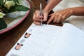 Making it official. an unrecognisable bride signing paperwork on her wedding day.