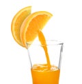 Making orange fresh. Juice pouring from orange citrus slices into glass on white background Royalty Free Stock Photo