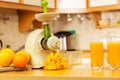 Making orange juice in juicer machine in kitchen Royalty Free Stock Photo