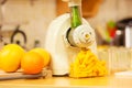 Making orange juice in juicer machine in kitchen Royalty Free Stock Photo