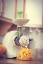 Making orange juice in juicer machine in kitchen Royalty Free Stock Photo