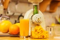 Making orange juice in juicer machine in kitchen Royalty Free Stock Photo