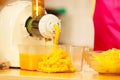 Making orange juice in juicer machine in kitchen Royalty Free Stock Photo