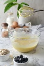 Making pancakes, cake, baking side view of baker hands pouring batter and whisking batter in bowl. Concept of Cooking ingredients Royalty Free Stock Photo