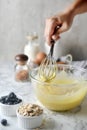 Making pancakes, cake, baking side view of baker hands pouring batter and whisking batter in bowl. Concept of Cooking ingredients Royalty Free Stock Photo