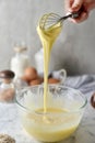 Making pancakes, cake, baking side view of baker hands pouring batter and whisking batter in bowl. Concept of Cooking ingredients Royalty Free Stock Photo