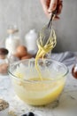 Making pancakes, cake, baking side view of baker hands pouring batter and whisking batter in bowl. Concept of Cooking ingredients Royalty Free Stock Photo