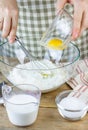 Making pastry dough. A baker adds an egg into the flour. Ingredients for baking