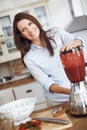 Making the perfect smoothie. An attractive woman using a blender to make a fruit smoothie. Royalty Free Stock Photo