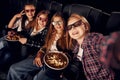 Making photo of each other. Group of kids sitting in cinema and watching movie together Royalty Free Stock Photo