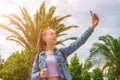 Making picture. Pretty female taking fun self portrait photo. Happy young girl with phone smile, typing texting and taking selfie