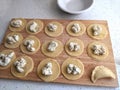 Making pierogis with ricotta, parmesan cheese, and parsley filling on a wooden board Royalty Free Stock Photo