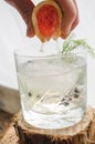 Making a Pink grapefruit and rosemary gin cocktail served in prepared glass on a tropical beach bar. Drink concept Royalty Free Stock Photo