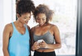 Making plans after yoga. Cropped shot of two young women looking at a cellphone after yoga class. Royalty Free Stock Photo