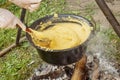 Making polenta in a traditional cast-iron pan in Transylvania, Romania